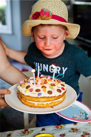 Boy blowing out candles on birthday cake Stock Photo - Premium Royalty-Free, Code: 649-09078034
