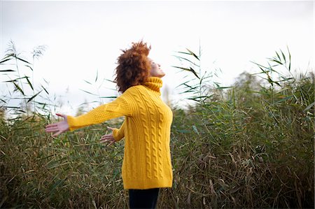 Side view of woman, arms open, head back, smiling Stock Photo - Premium Royalty-Free, Code: 649-09078106