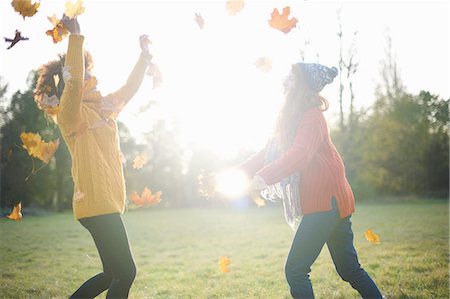 friends back lit - Friends throwing autumn leaves in air Stock Photo - Premium Royalty-Free, Code: 649-09078121