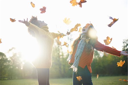 friends back lit - Friends throwing autumn leaves in air Stock Photo - Premium Royalty-Free, Code: 649-09078123