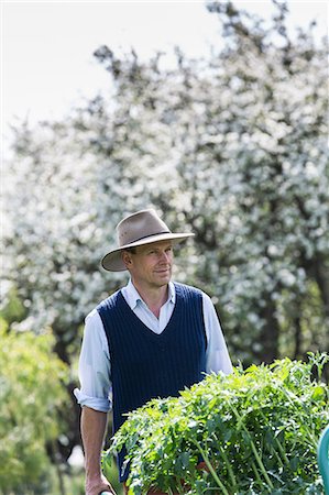 Farmer pushing barrow of plants Photographie de stock - Premium Libres de Droits, Code: 649-09078141