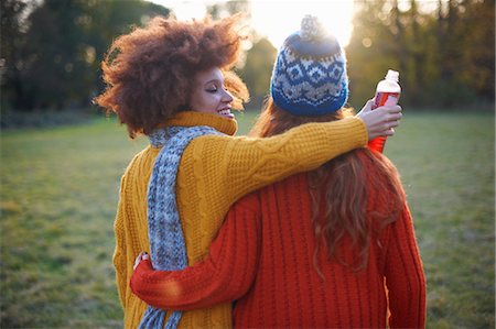 photo of autumn in england - Two young women, in rural setting, walking with arms around each other, rear view Stock Photo - Premium Royalty-Free, Code: 649-09078221