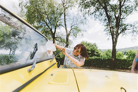 people in yellow - Young woman on road trip cleaning windscreen, Como, Lombardy, Italy Stock Photo - Premium Royalty-Free, Code: 649-09078259