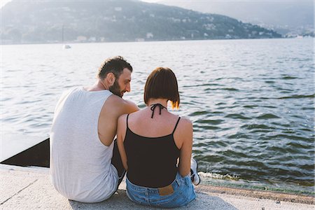 simsearch:649-09078282,k - Rear view of young couple sitting on waterfront, Lake Como, Lombardy, Italy Stock Photo - Premium Royalty-Free, Code: 649-09078271