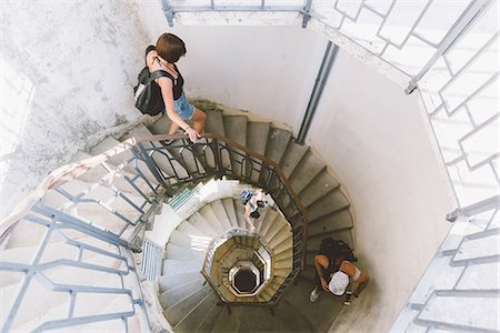 High angle view of three young adults moving down spiral staircase, Como, Lombardy, Italy Fotografie stock - Premium Royalty-Free, Codice: 649-09078291