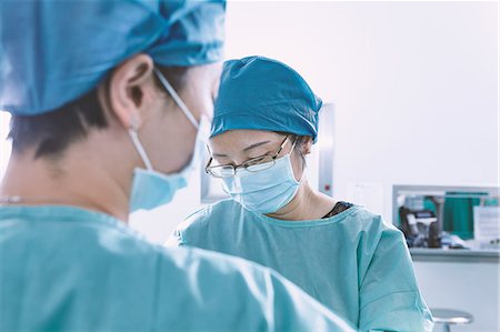 simsearch:649-09078375,k - Over shoulder view of surgeon performing operation in maternity ward operating theatre Stock Photo - Premium Royalty-Free, Code: 649-09078346
