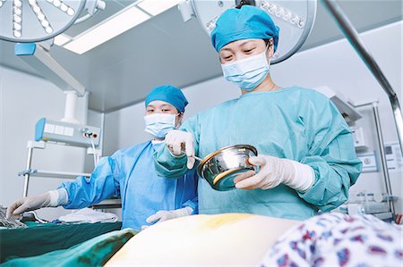 simsearch:649-09078375,k - Female surgeon preparing patients abdomen in maternity ward operating theatre Stock Photo - Premium Royalty-Free, Code: 649-09078340