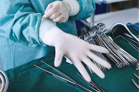 simsearch:649-09078375,k - Surgeon putting on surgical gloves in maternity ward operating theatre Stock Photo - Premium Royalty-Free, Code: 649-09078343