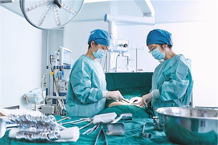 simsearch:649-09078375,k - Surgeons performing surgery on patient abdomen in maternity ward operating theatre Stock Photo - Premium Royalty-Free, Code: 649-09078363