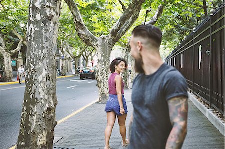 simsearch:649-09078437,k - Young male hipster and woman looking back on sidewalk, Shanghai French Concession, Shanghai, China Stock Photo - Premium Royalty-Free, Code: 649-09078424