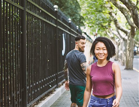 simsearch:649-09078437,k - Young male hipster looking back at woman on sidewalk, Shanghai French Concession, Shanghai, China Stock Photo - Premium Royalty-Free, Code: 649-09078425