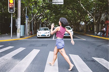 simsearch:649-09078437,k - Woman marching across pedestrian crossing, Shanghai French Concession, Shanghai, China Stock Photo - Premium Royalty-Free, Code: 649-09078427