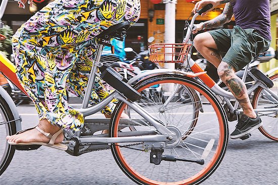 Waist down view of multi ethnic hipster couple cycling along street, Shanghai French Concession, Shanghai, China Stock Photo - Premium Royalty-Free, Image code: 649-09078420