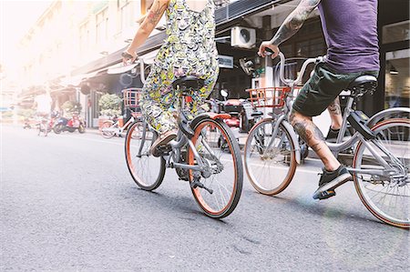 Waist down view of multi ethnic hipster couple cycling along street, Shanghai French Concession, Shanghai, China Foto de stock - Sin royalties Premium, Código: 649-09078421