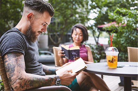 simsearch:649-09078412,k - Multi ethnic hipster couple reading books at sidewalk cafe, Shanghai French Concession, Shanghai, China Fotografie stock - Premium Royalty-Free, Codice: 649-09078434