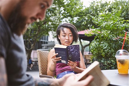 simsearch:614-08270079,k - Multi ethnic hipster couple reading books at sidewalk cafe, Shanghai French Concession, Shanghai, China Stock Photo - Premium Royalty-Free, Code: 649-09078433