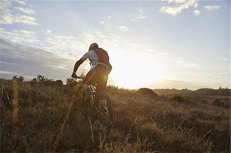 Male mountain biker biking on moorland track in sunlight Foto de stock - Sin royalties Premium, Código: 649-09078450