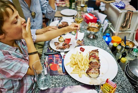 Boy eating meal at restaurant, Montevideo, Uruguay, South America Photographie de stock - Premium Libres de Droits, Code: 649-09078601