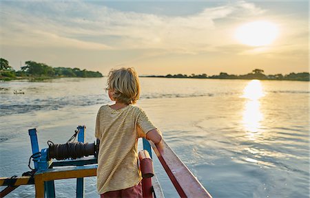 Boy looking away at view of sunset over lake, Bonito, Mato Grosso do Sul, Brazil, South America Stock Photo - Premium Royalty-Free, Code: 649-09078633