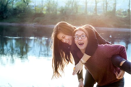 simsearch:649-08086803,k - Young woman giving best friend piggy back by river, Calolziocorte, Lombardy, Italy Fotografie stock - Premium Royalty-Free, Codice: 649-09111163