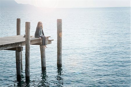 simsearch:649-07520942,k - Woman sitting on pier looking away Foto de stock - Sin royalties Premium, Código: 649-09111194