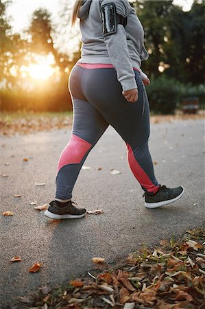 energetic woman walking - Curvaceous young woman training, neck down view walking in park Stock Photo - Premium Royalty-Free, Code: 649-09111296
