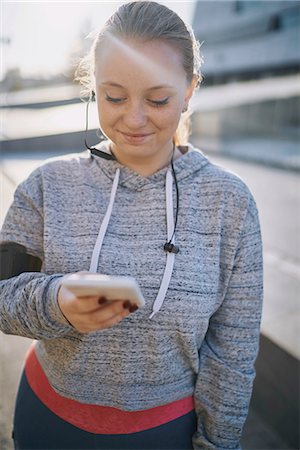 simsearch:649-09111302,k - Curvaceous young woman training, looking at smartphone Stock Photo - Premium Royalty-Free, Code: 649-09111309