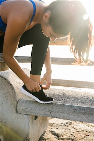 simsearch:649-09111421,k - Young woman training on beach, tying trainer laces Stock Photo - Premium Royalty-Free, Code: 649-09111398