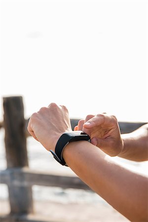 simsearch:649-09111421,k - Young woman training on sea waterfront looking at smartwatch, close up of hands Stock Photo - Premium Royalty-Free, Code: 649-09111404