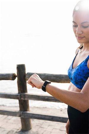 simsearch:649-09111421,k - Young woman training on sea waterfront, looking at smartwatch Stock Photo - Premium Royalty-Free, Code: 649-09111403