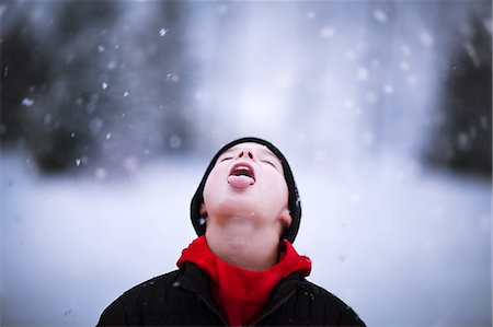 sticking out tongue in snow - Portrait of boy catching falling snow on tongue Stock Photo - Premium Royalty-Free, Code: 649-09111546