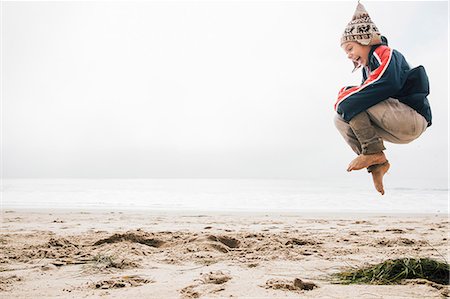 Young boy on beach,jumping, mid air Stock Photo - Premium Royalty-Free, Code: 649-09111568