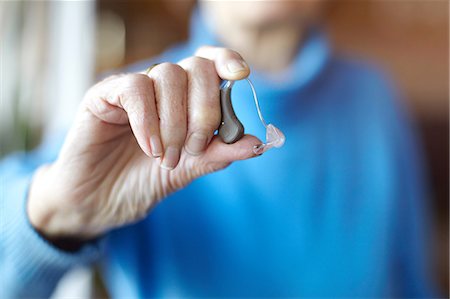 simsearch:614-08884947,k - Senior woman holding hearing aid, close-up Foto de stock - Royalty Free Premium, Número: 649-09111581