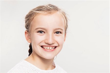 preteen girl t shirt white background - Studio portrait of girl with toothy smile, head and shoulders Stock Photo - Premium Royalty-Free, Code: 649-09111644