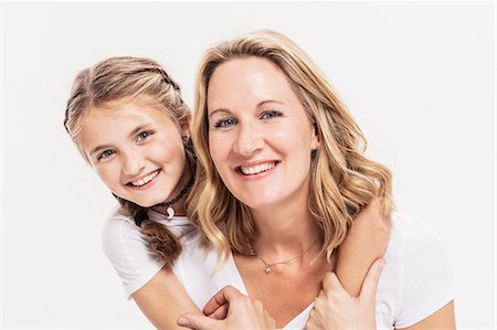 Studio portrait of girl with arms around her mother, head and shoulders Stock Photo - Premium Royalty-Free, Code: 649-09111675