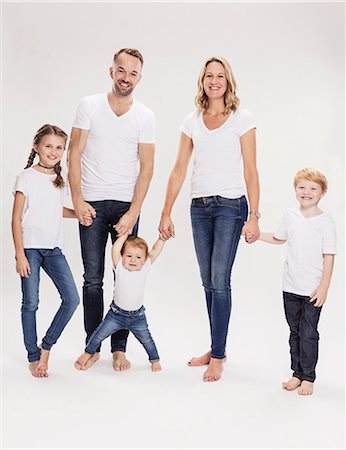 simsearch:695-03379424,k - Studio portrait of mature couple holding hands with daughter  and sons, full length Foto de stock - Sin royalties Premium, Código: 649-09111673