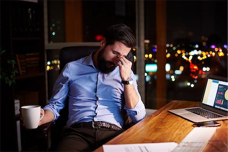 Tired young businessman at office desk at night Foto de stock - Sin royalties Premium, Código: 649-09124008