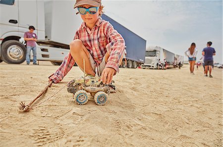 Boy playing with toy truck in sand, Ica, Peru Stock Photo - Premium Royalty-Free, Code: 649-09123248