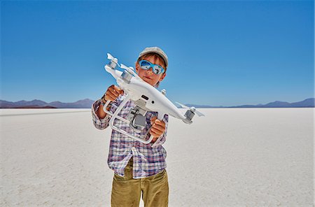 freedom child - Portrait of boy on salt flats, holding drone, Salar de Uyuni, Uyuni, Oruro, Bolivia, South America Stock Photo - Premium Royalty-Free, Code: 649-09123287