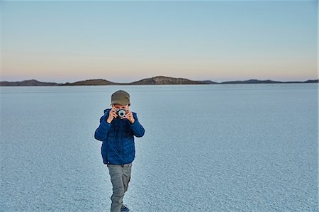 Young boy standing on salt flats, looking through camera, Salar de Uyuni, Uyuni, Oruro, Bolivia, South America Stock Photo - Premium Royalty-Free, Code: 649-09123290