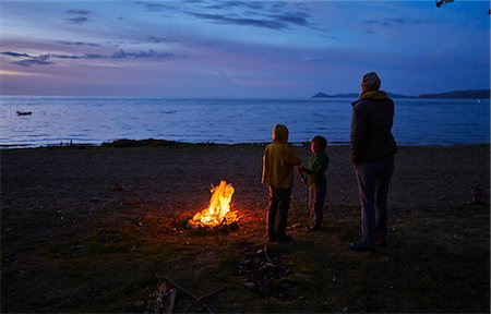 Mother and sons beside camp fire, looking at lake view, rear view, Copacabana, Oruro, Bolivia, South America Stock Photo - Premium Royalty-Free, Code: 649-09123338