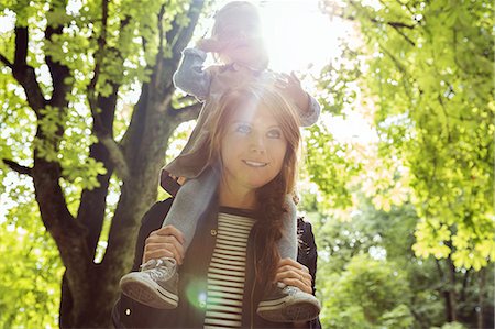 Mother giving toddler daughter shoulder carry in sunlit park Photographie de stock - Premium Libres de Droits, Code: 649-09123378