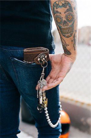 simsearch:649-08060336,k - Rear view of man with keys in back pocket and skull tattoo, cropped Stock Photo - Premium Royalty-Free, Code: 649-09123395