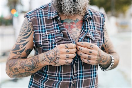 simsearch:649-09123411,k - Tattooed male hipster fastening shirt buttons, cropped Stock Photo - Premium Royalty-Free, Code: 649-09123408