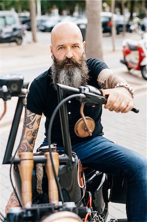 simsearch:649-09123400,k - Portrait of mature male hipster astride motorcycle in parking lot Foto de stock - Sin royalties Premium, Código: 649-09123400