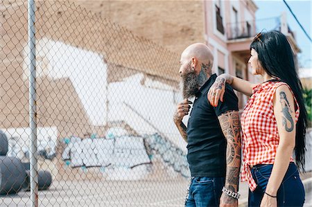 simsearch:649-09123411,k - Mature hipster couple looking beyond wire fence Stock Photo - Premium Royalty-Free, Code: 649-09123437
