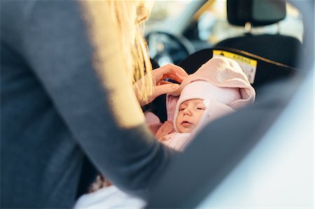 simsearch:400-08500664,k - Mother fastening young baby in car seat, mid section Stock Photo - Premium Royalty-Free, Code: 649-09123525