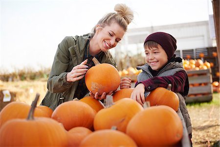 simsearch:6115-06732993,k - Young woman and boy selecting pumpkins in pumpkin patch field Photographie de stock - Premium Libres de Droits, Code: 649-09123603