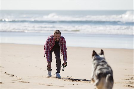 simsearch:649-08840788,k - Dog running to male owner on beach Foto de stock - Sin royalties Premium, Código: 649-09123634