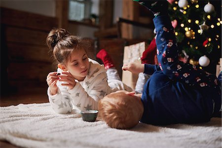 simsearch:649-06001802,k - Young girl and boy relaxing beside Christmas tree Photographie de stock - Premium Libres de Droits, Code: 649-09123671